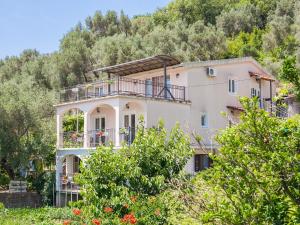 une maison sur une colline avec des arbres dans l'établissement Apartments Midžor, à Petrovac na Moru