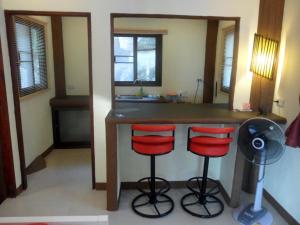 a kitchen with a counter and two red bar stools at Moonstone Studio in Haad Rin