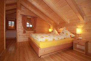 シャルニッツにあるHarrys Hütteの木造キャビン内のベッド1台が備わるベッドルーム1室を利用します。