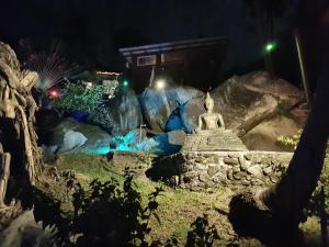 a statue in the middle of a garden at night at Moonstone Studio in Haad Rin