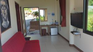 a living room with a red couch and a tv at Moonstone Studio in Haad Rin