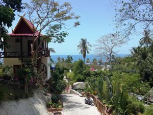 a road leading to a house with plants and trees at Moonstone Studio in Haad Rin
