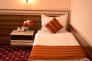 a hotel room with a bed and a table with a phone at Artsakh Hotel in Yerevan