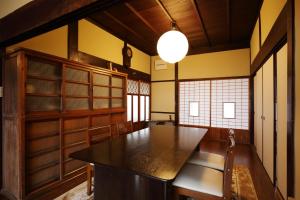 a dining room with a large wooden table and chairs at Hoshikuzu in Naoshima