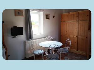 a dining room with a table and chairs and a window at La Ferme du Parc in Pendé