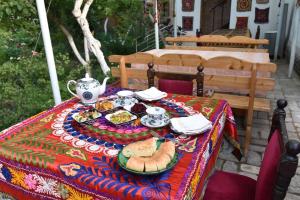 a table with a plate of food on it at ANTICA Family Guest House in Samarkand
