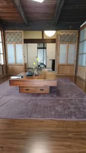 a large room with a wooden table and a large rug at Hoshikuzu in Naoshima