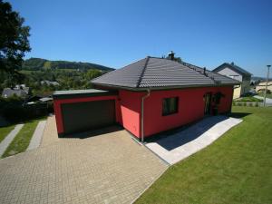 ein kleines rotes Haus mit Garage im Hof in der Unterkunft Ferienwohnung Rinno in Olbernhau