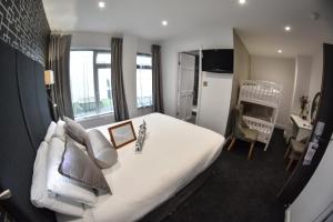 a bedroom with a large white bed and a desk at Cumberland Hotel - OCEANA COLLECTION in Bournemouth