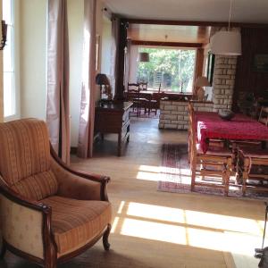 sala de estar con sofá, mesa y sillas en La grande maison de Carrouges en Carrouges