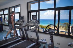 a man in a gym with a view of the ocean at Tus'Hotel in Castel di Tusa