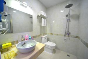 a bathroom with a sink and a shower and a toilet at Emeishan Moon Bay Hotel in Emeishan City