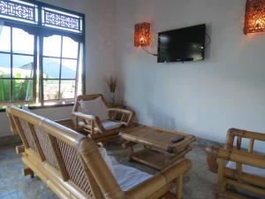 sala de estar con sillas y TV de pantalla plana en Lemon House, en Padangbai