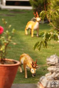 two fake deer standing in the grass near a plant at Aarya Chaitya Inn in Kathmandu