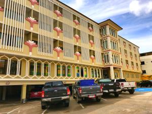 un gran edificio con camiones estacionados frente a él en Poonsook Phitsanulok Hotel SHA Plus, en Phitsanulok