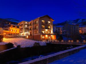a building with lights on at night at Hôtel Le Chalet in Ax-les-Thermes