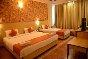 Postel nebo postele na pokoji v ubytování Goa Woodlands Hotel