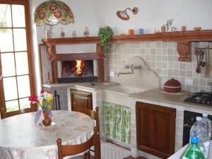 a kitchen with a fireplace and a table with a table sidx sidx sidx at Villa Rocca in Marciaga