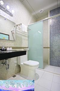 a bathroom with a toilet and a glass shower at Zhen Ai B&B in Wujie