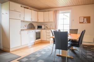 a kitchen and dining room with a table and chairs at Enjoy Resorts Marina Fiskenæs in Gråsten