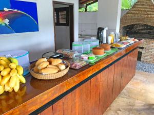 a buffet with bread and other food on a counter at Tucano Pousada in Cumbuco