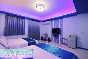 Habitación de hotel con 2 camas y TV en Zhen Ai B&B, en Wujie