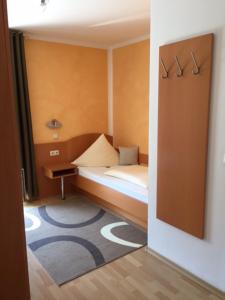 a small bedroom with a bed and a rug at Pension Wagner in Ingolstadt