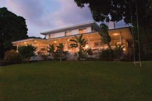 une grande maison avec une pelouse devant elle dans l'établissement Ka'awa Loa Plantation, à Captain Cook