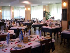 a dining room filled with tables and chairs with white tablecloths at Hotel Ristorante Giardino in Abbadia San Salvatore