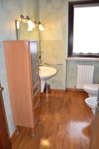 bagno con lavandino, servizi igienici e specchio di Casa di Karim a Pescantina