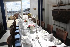 a long table with glasses and flowers on it at Hummeren Hotel in Tananger +70 photos