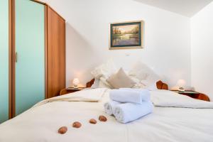 een slaapkamer met een wit bed met handdoeken erop bij Croatica Suites Podsolarsko in Šibenik +74 foto's