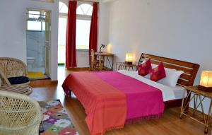 a bedroom with a large bed with a red blanket at Seventh Heaven Inn Rishikesh in Rishīkesh