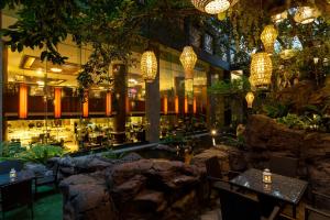 ein Restaurant mit Tischen, Stühlen und Lichtern in der Unterkunft Banyan Tree Bangkok in Bangkok