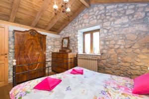 a bedroom with a bed and a stone wall at Villa Milena in Brseč +18 photos