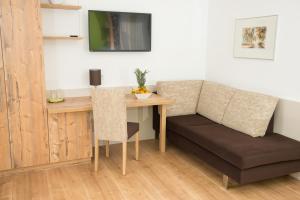 um quarto com uma mesa, um sofá e uma secretária em Lorenzerhof em Sankt Lorenzen am Wechsel