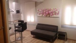 a waiting room with a chair and a table at Apartamentos Mitreo in Mérida
