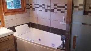 a bath tub in a bathroom with a sink at Chalet Helalph in La Bresse +2 photos