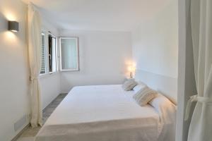 biała sypialnia z dużym łóżkiem i oknem w obiekcie Apartamento Ferrera Park 622 w mieście Cala Ferrera +25 zdjęć