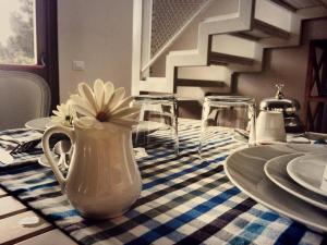 a white vase with a flower in it on a table at B&B Le Biciclette in San Vito lo Capo