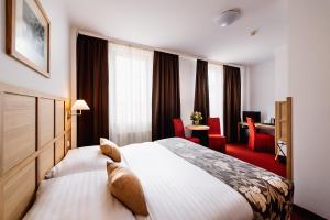 una camera d'albergo con un grande letto e una scrivania di Central Hotel Prague a Praga