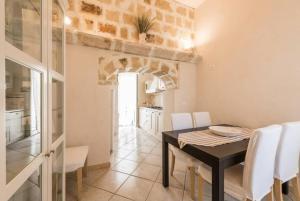 a kitchen and dining room with a table and white chairs at Domus Chiara in Monopoli