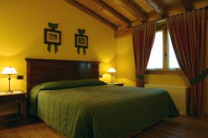 a bedroom with a green bed and a window at Agriturismo Vigneto Vecio in Valdobbiadene