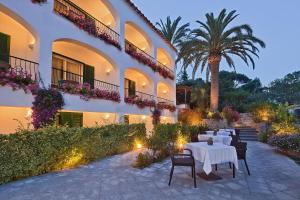 a patio with a table and chairs in front of a building at Hotel Della Piccola Marina in Capri