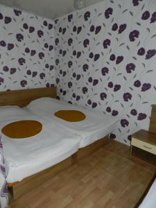 sypialnia z łóżkiem i tapetą w kwiaty w obiekcie Letovishte Romantika w Kamcziji