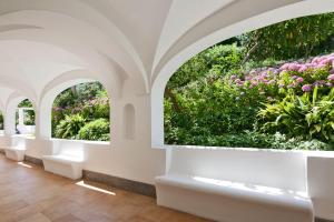 an indoor garden with pink flowers and plants at Hotel Della Piccola Marina in Capri