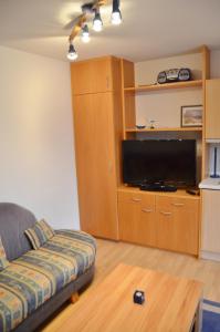a living room with a couch and a flat screen tv at Haus Windrose in Norderney