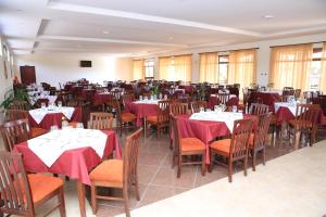 uma sala de jantar com mesas e cadeiras com guardanapos vermelhos em Haile Resort Ziway Batu em Ziway