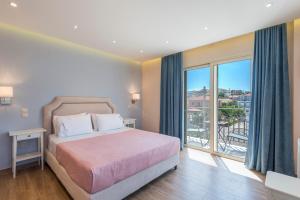 a bedroom with a bed and a large window at Pansion Ermioni in Skala