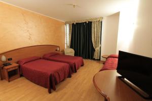 a hotel room with two beds and a television at Hotel Europa in Biella